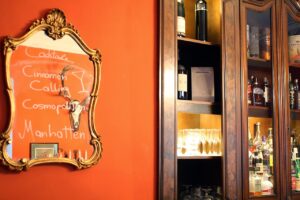 Warm bar interior with bottles and handwritten cocktail menu
